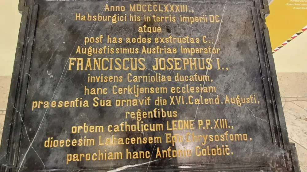 Plo&scaron;ča iz črnega marmorja, shranjena v zakristiji cerkve v Cerkljah, na katero so jo vzidali v spomin na cesarjev obisk.
