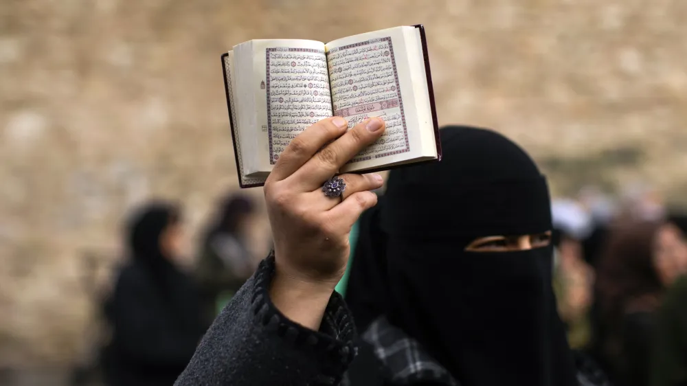 FILE - A woman holds up a Quran during a protest outside the Swedish consulate in Istanbul, Turkey, on Jan. 22, 2023. Turkish President Recep Tayyip Erdogan's abrupt approval of Sweden's NATO bid came after a year of objections to Stockholm to joining the defense alliance. (AP Photo/Francisco Seco, File)