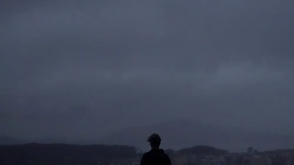 A person looks north from Grand View Park in San Francisco, Wednesday, Jan. 11, 2023. Storm-ravaged California is scrambling to clean up and repair widespread damage. (AP Photo/Jeff Chiu)