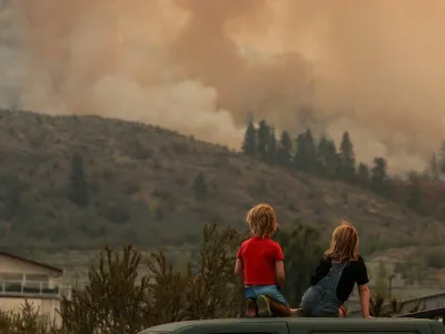 ocals gather to watch firefighting efforts amid heavy smoke from the Eagle Bluff wildfire, after it crossed the Canada-U.S. border from the state of Washington and prompted evacuation orders, in Osoyoos, British Columbia, Canada July 30.