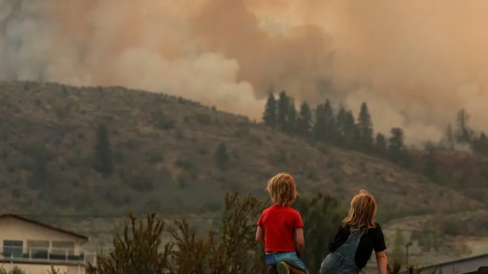 ocals gather to watch firefighting efforts amid heavy smoke from the Eagle Bluff wildfire, after it crossed the Canada-U.S. border from the state of Washington and prompted evacuation orders, in Osoyoos, British Columbia, Canada July 30.