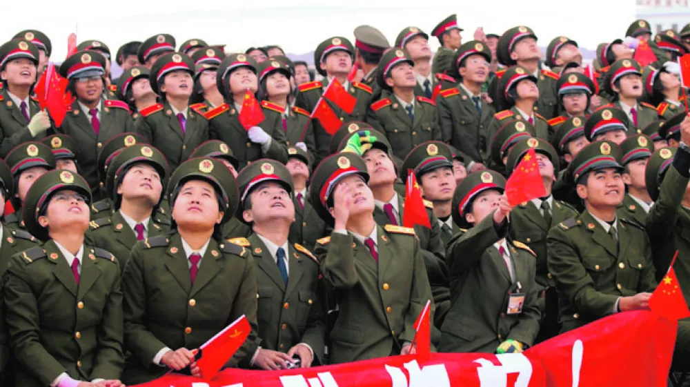 Soldiers watch the Long March CZ-2F rocket carrying the Shenzhou VI blast off at the Jiuquan Satellite Launch Center, October 12, 2005. China's second manned spacecraft blasted off from a remote northwestern launch site on Wednesday, two years after the country joined an elite club of space powers. CHINA OUT REUTERS/China Newsphoto------2k