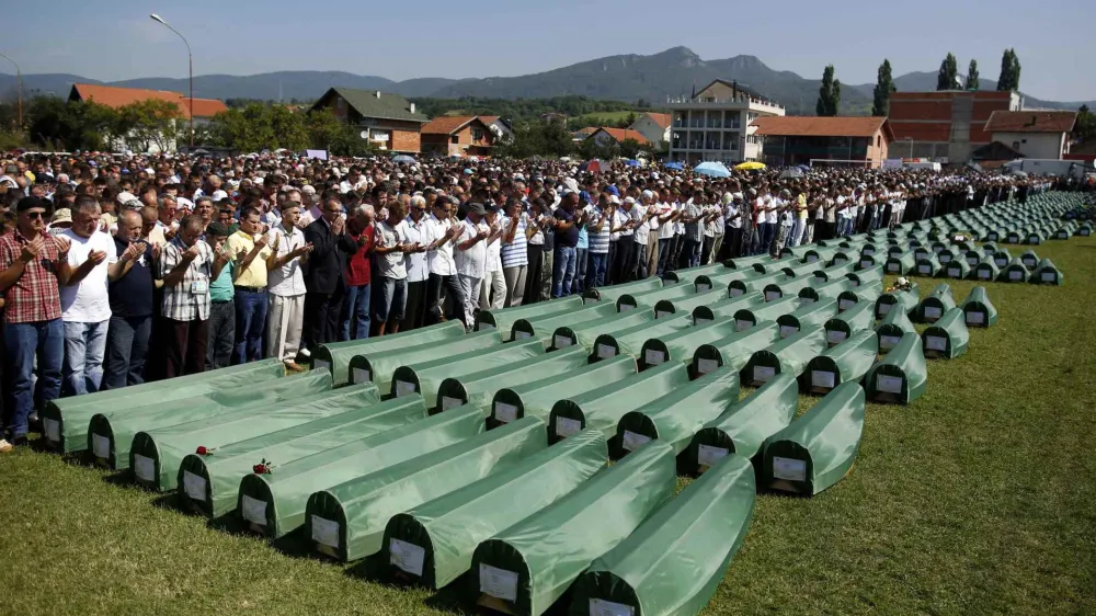 ﻿Bosnian Muslims pray near the coffins of relatives during mass funeral for bodies found in a mass grave, in Kozarac, near Prijedor, July 20, 2014. The collective burial of 284 Bosnian Muslims and Croats, whose remains were found and identified in a northwestern mass grave and believed to be the largest from Bosnia's 1992-95 war, will take place on Sunday. REUTERS/Dado Ruvic (BOSNIA AND HERZEGOVINA - Tags: POLITICS CIVIL UNREST CONFLICT RELIGION)