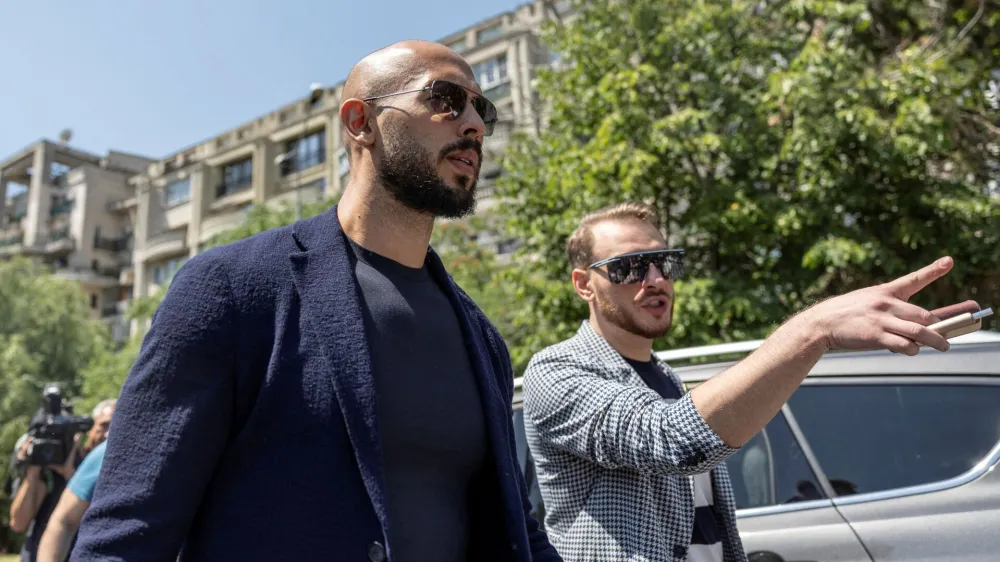 FILE PHOTO: Andrew Tate chats with his lawyer after he appeared in front of a judge at the Bucharest Courthouse, in Bucharest, Romania, July 17, 2023. Inquam Photos/Alexandru Busca via REUTERS ATTENTION EDITORS - THIS IMAGE WAS PROVIDED BY A THIRD PARTY. ROMANIA OUT. NO COMMERCIAL OR EDITORIAL SALES IN ROMANIA/File Photo