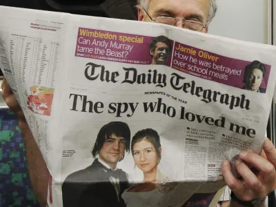 A passenger reads the Daily Telegraph newspaper, featuring a front page interview with the ex-husband of accused Russian spy Anna Chapman, on the underground in London July 2, 2010. Chapman, one of 10 arrested, was denied bail on Monday in New York after U.S. authorities said they broke up a spy ring that carried out deep-cover work in the United States to recruit political sources and gather information for the Russian government. REUTERS/Luke MacGregor (BRITAIN - Tags: CRIME LAW MILITARY POLITICS)