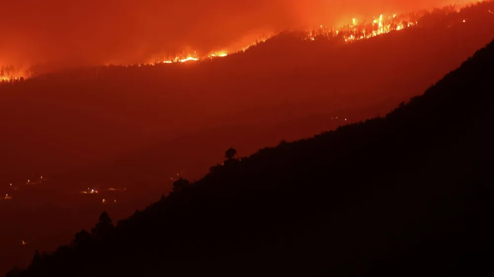 A view shows a fire over the mountains near empty houses after the evacuation in different villages in the north, as wildfires rage out of control on the island of Tenerife, Canary Islands, Spain August 20, 2023. REUTERS/Nacho Doce