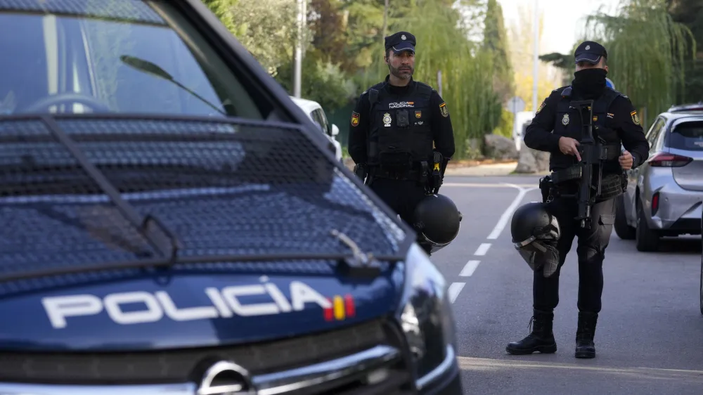 Police officers stand guard as they cordon off the area next to the Ukrainian embassy in Madrid, Spain, Wednesday, Nov. 30, 2022. Spain's Interior Ministry says police are investigating reports of a blast at the Ukrainian embassy in Madrid. The ministry says police were told an employee at the embassy was slightly injured handling a letter in what it described as "a deflagration." (AP Photo/Paul White)