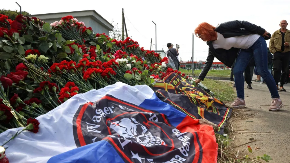 Ženska polaga cvetje v Sankt Peterburgu, enem od ruskih mest, kjer so se na ta način spomnili Jevgenija Prigožina. Foto: Reuters