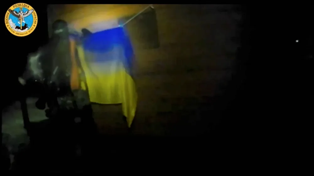 A Ukrainian soldier hangs a Ukrainian flag during a 'special operation' by Ukrainian forces at a location given as near Olenivka and Mayak settlements, Crimea, in this screengrab obtained from a handout video released on August 24, 2023. Ukrainian Main Directorate of Intelligence/Handout via REUTERS  THIS IMAGE HAS BEEN SUPPLIED BY A THIRD PARTY. MANDATORY CREDIT