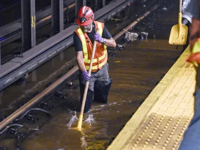 This photo, provided by MTA New York City Transit, shows an MTA worker knee-deep in water on subway tracks from a water main break in New York's Times Square, Tuesday, Aug. 29, 2023. A 127-year-old, 20-inch water main under New York's Times Square gave way early Tuesday, flooding midtown streets and the city's busiest subway station. (Marc A. Hermann / MTA, via AP)