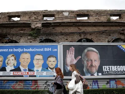 Women walk past election posters in Sarajevo, Bosnia, September 25, 2022. REUTERS/Dado Ruvic