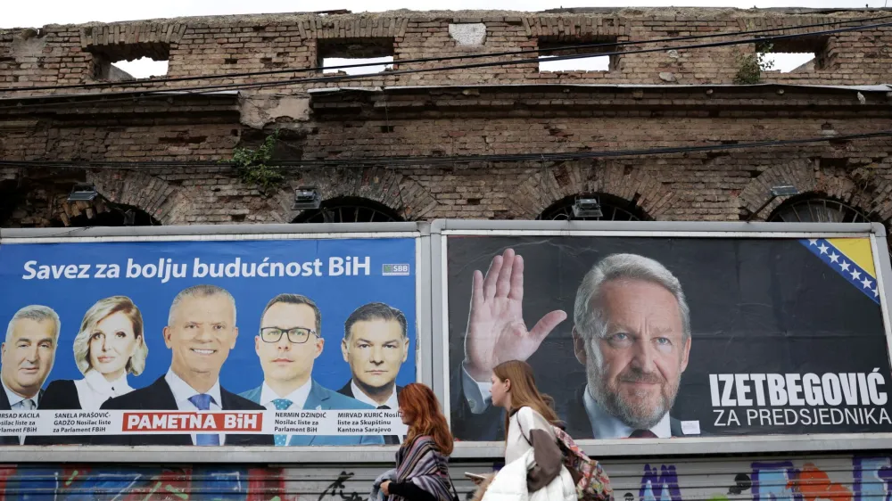 Women walk past election posters in Sarajevo, Bosnia, September 25, 2022. REUTERS/Dado Ruvic