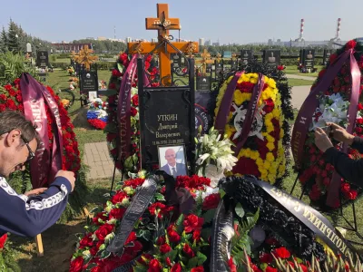 Journalists take photos of the grave of Dmitry Utkin, who oversaw Wagner Group's military operations, at the Federal Military Memorial Cemetery in Mytishchy, outside Moscow, Russia, Thursday, Aug. 31, 2023. Utkin, whose military call sign Wagner gave the name to the group, is presumed to have died in a plane crash along with Wagner's owner Yevgeny Prigozhin and other military company's officers was buried at the Federal Military Memorial Cemetery in Mytishchy, outside Moscow on Thursday. (AP Photo/Alexander Zemlianichenko)
