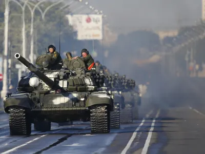 FILE - Heat haze rises around a column of Belarus army tanks as they join the rehearsal for the Independence Day military parade in Minsk, Belarus, Wednesday, June 29, 2016. Belarus this week once again accused Ukraine of planning to attack it and announced creating a joint grouping of troops with Moscow, a move that stocked fears that Belarusian army could join Russian forces in Ukrainian trenches. (AP Photo, File)