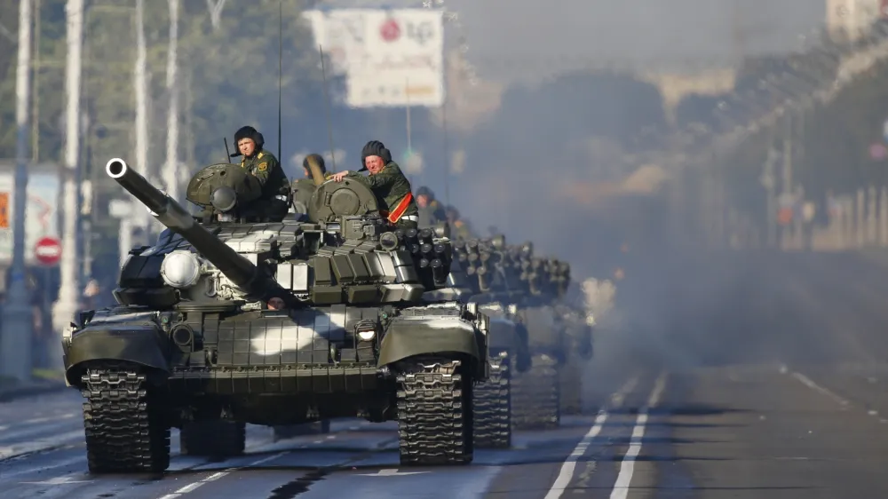 FILE - Heat haze rises around a column of Belarus army tanks as they join the rehearsal for the Independence Day military parade in Minsk, Belarus, Wednesday, June 29, 2016. Belarus this week once again accused Ukraine of planning to attack it and announced creating a joint grouping of troops with Moscow, a move that stocked fears that Belarusian army could join Russian forces in Ukrainian trenches. (AP Photo, File)