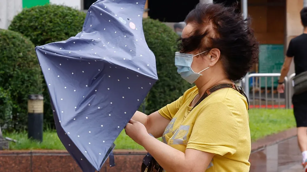 A woman holds an umbrella while walking on the streets in Taipei after the Haikui Typhoon hit Taiwan, in Taipei, Taiwan September 4, 2023. REUTERS/Ann Wang