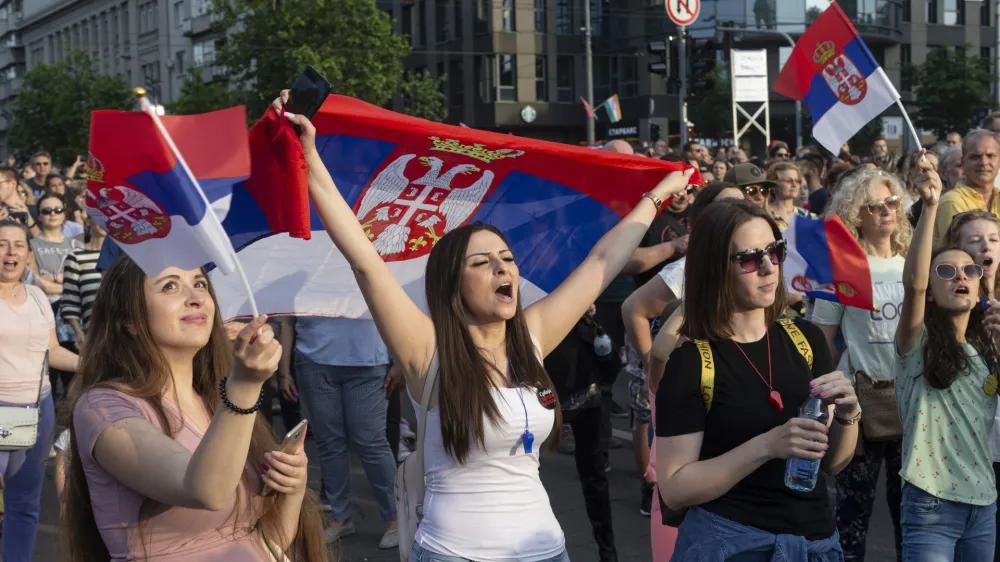 A woman shouts as she holds a Serbian flag during a protest in Belgrade, Serbia, Friday, June 9, 2023. Tens of thousands of people rallied in Serbia's capital on Friday in protest of the government's handling of a crisis after two mass shootings in the Balkan country. (AP Photo/Marko Drobnjakovic)