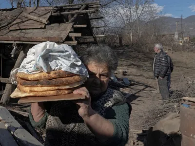 FILE PHOTO: Local resident Zina Fatyan carries freshly baked bread in the village of Taghavard in the region of Nagorno-Karabakh, January 15, 2021. Picture taken January 15, 2021. REUTERS/Artem Mikryukov/File Photo