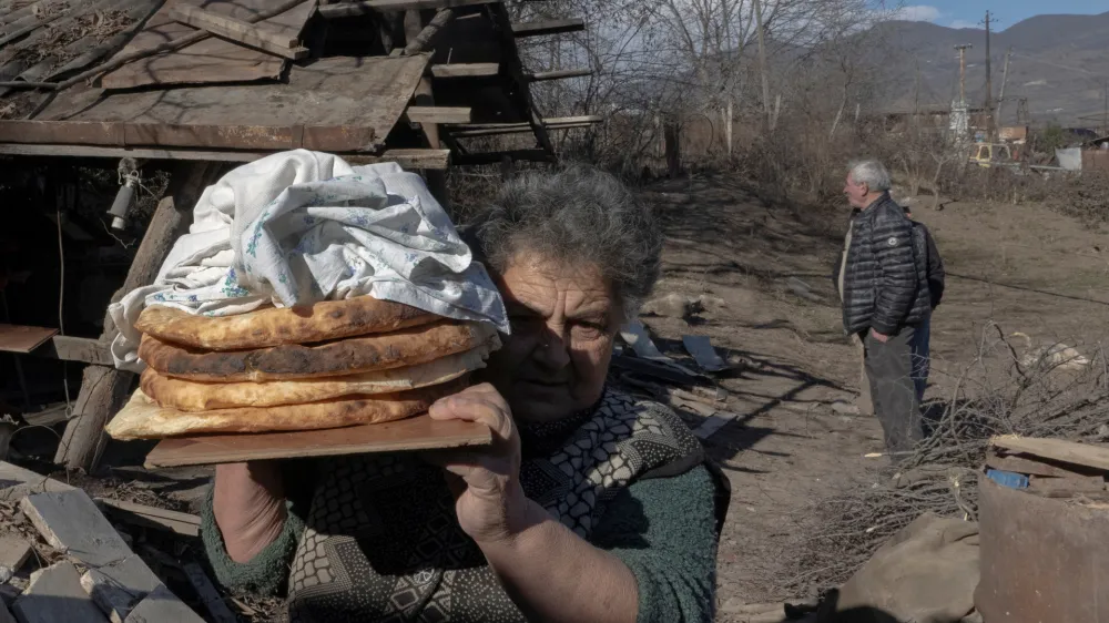 FILE PHOTO: Local resident Zina Fatyan carries freshly baked bread in the village of Taghavard in the region of Nagorno-Karabakh, January 15, 2021. Picture taken January 15, 2021. REUTERS/Artem Mikryukov/File Photo