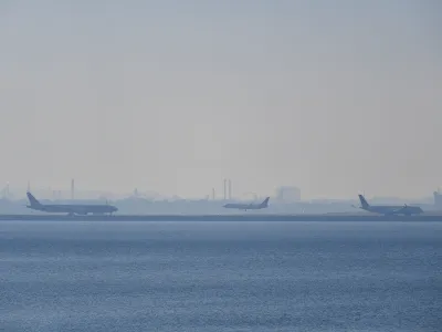 Airplanes are seen on the runway as smoke blankets the skyline in Sydney, Wednesday, September 13, 2023. Parts of Sydney are blanketed in a smoke haze caused by weekend hazard reduction burns as fire authorities prepare the state for the looming bushfire season. (AAP Image/Bianca De Marchi) NO ARCHIVING