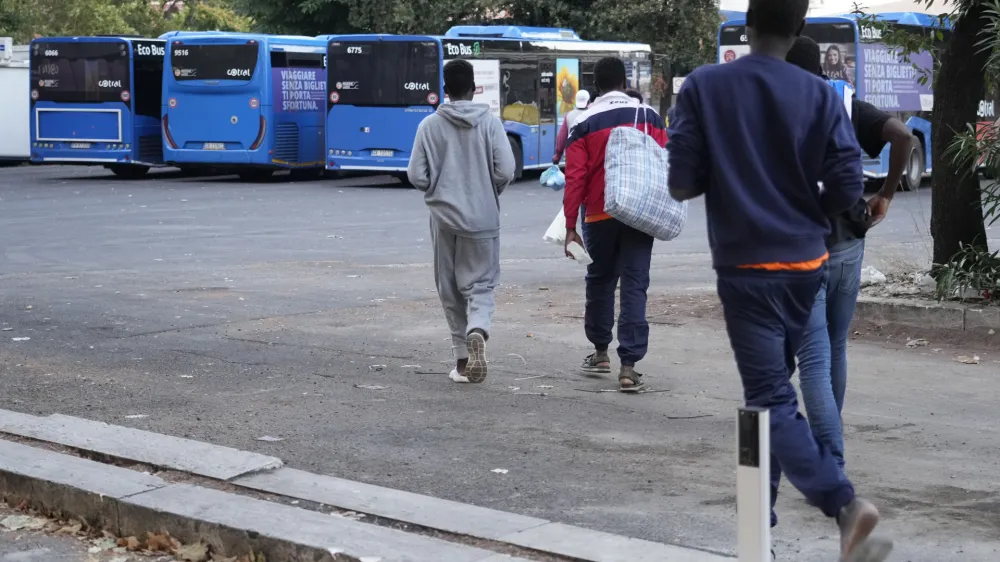 Migrants walk towards a station to board a bus directed to Marseille, France, in Rome, Tuesday, Sept. 12, 2023. Ten years after Pope Francis made a landmark visit to the Italian island of Lampedusa to show solidarity with migrants, he is joining Catholic bishops from around the Mediterranean this weekend in France to make the call more united, precisely at the moment that European leaders are again scrambling to stem the tide of would-be refugees setting off from Africa. (AP Photo/Gregorio Borgia)