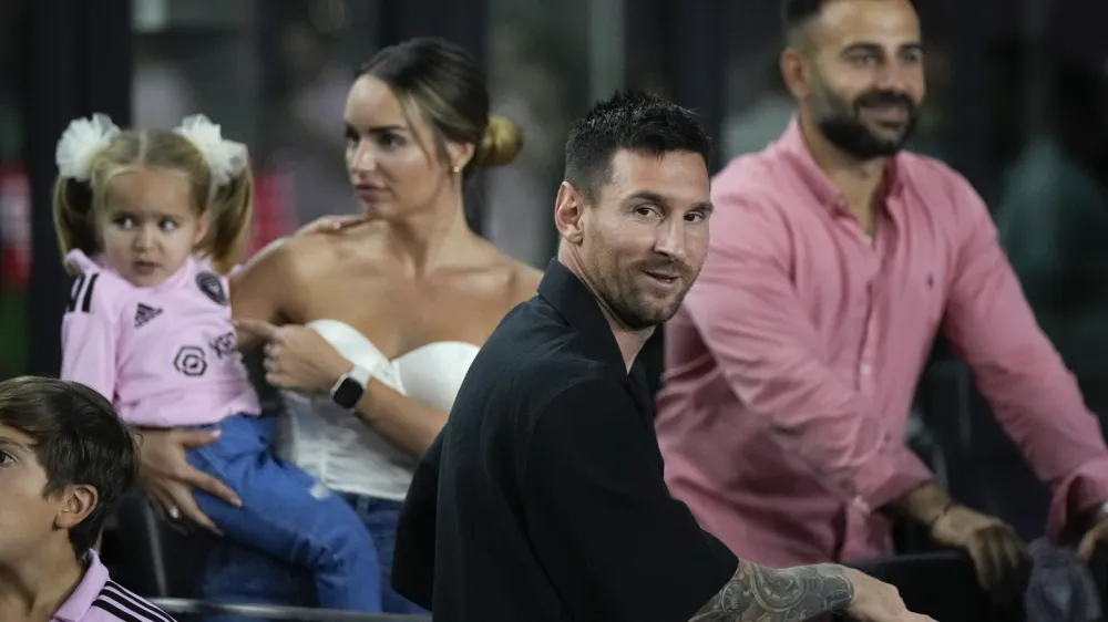 Inter Miami forward Lionel Messi, front, greets friends inside a private box at the start of the team's U.S. Open Cup final soccer match against the Houston Dynamo, Wednesday, Sept. 27, 2023, in Fort Lauderdale, Fla. (AP Photo/Rebecca Blackwell)