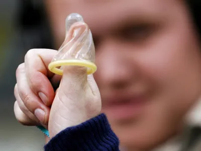 A member of the No To Pope Coalition displays a condom on her thumb during a media call in Sydney in this July 4, 2008 file photo. Using condoms may sometimes be justified to stop the spread of AIDS, Pope Benedict says in a new book, in surprise comments that relax one of the Vatican's most controversial positions. REUTERS/Daniel Munoz/Files (AUSTRALIA - Tags: RELIGION SOCIETY)