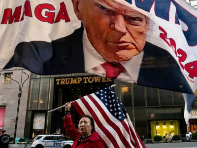 A supporter of former U.S. President Donald Trump holds up a U.S. national flag at Trump Tower in New York City, U.S., October 1, 2023. REUTERS/David 'Dee' Delgado   TPX IMAGES OF THE DAY