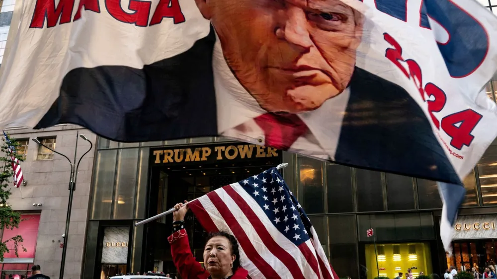 A supporter of former U.S. President Donald Trump holds up a U.S. national flag at Trump Tower in New York City, U.S., October 1, 2023. REUTERS/David 'Dee' Delgado   TPX IMAGES OF THE DAY