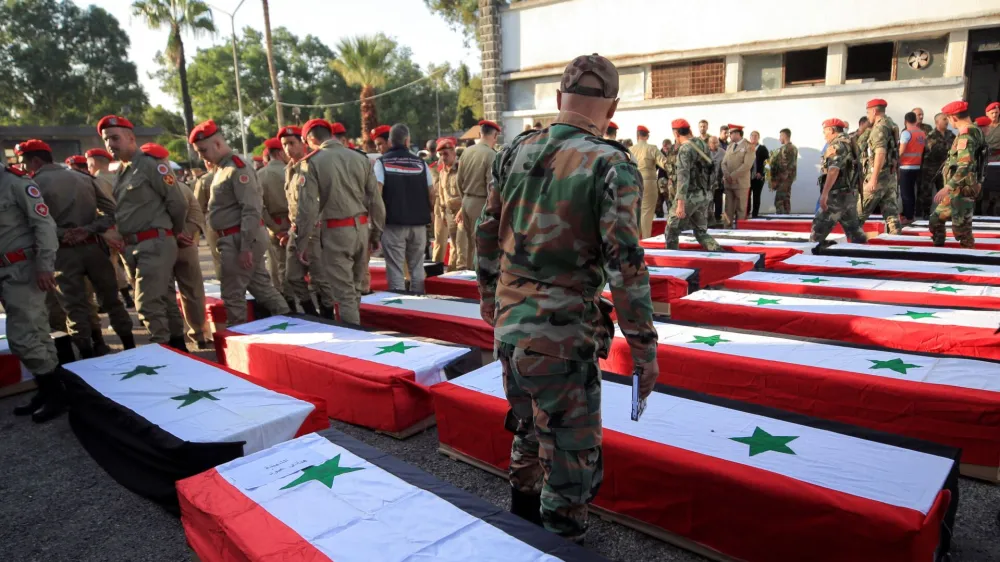 Coffins carrying the bodies of some of the people killed in an attack on a military academy, lie on the ground outside a military hospital in Homs, Syria October 6, 2023. REUTERS/Yamam al Shaar