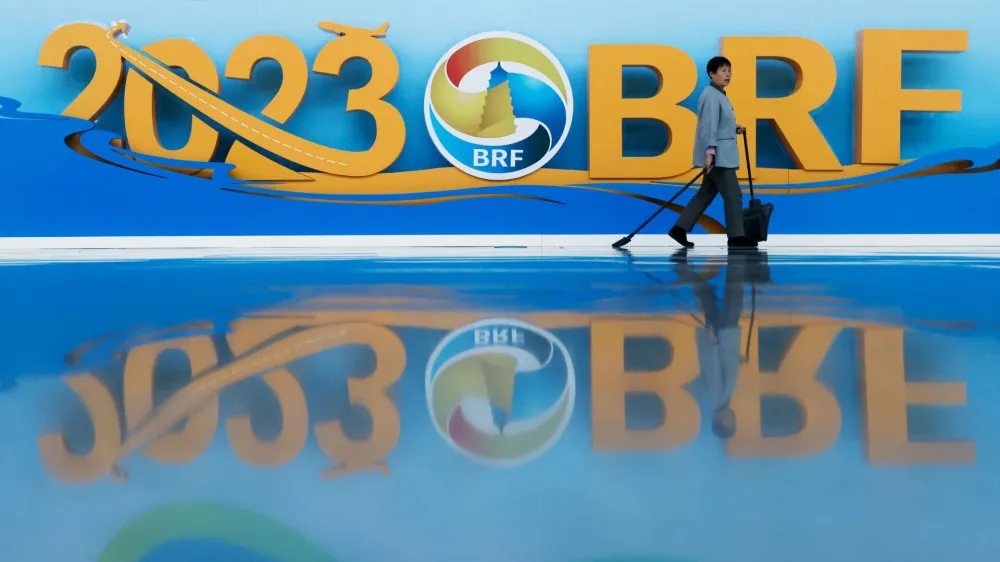 A cleaner walks past signage at China National Convention Center ahead of the Third Belt and Road Forum in Beijing, China October 16, 2023. REUTERS/Edgar Su