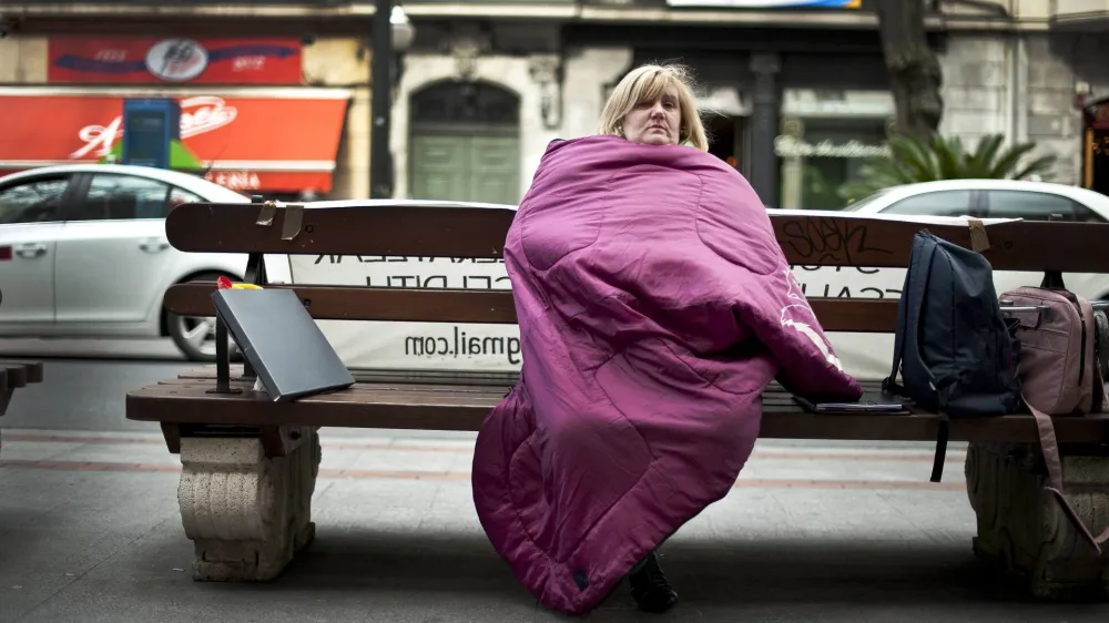 Marta Uriarte wraps herself up in a sleeping bag at the beginning of her hunger strike in protest against her forthcoming eviction, after failing to pay the mortgage on her house, in front of the Bilbao Bizkaia Kutxa (BBK) bank in central Bilbao, in this file picture taken March 5, 2012. Spanish banks will learn from an audit on September 28, 2012, the extent of the damage from the collapse of a real estate boom that left the sector with 184 billion euros in repossessions and bad loans. REUTERS/Vincent West/Files (SPAIN - Tags: BUSINESS CIVIL UNREST SOCIETY POVERTY REAL ESTATE)