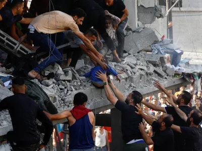 Palestinians carry a child casualty at the site of an Israeli strike on a house, in Khan Younis, in the southern Gaza Strip, October 24, 2023. REUTERS/Ibraheem Abu Mustafa