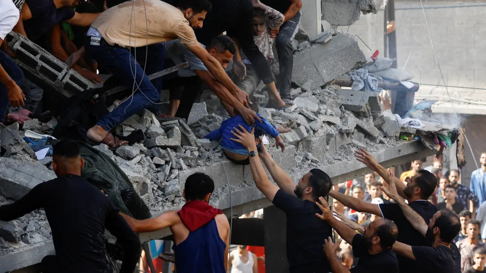 Palestinians carry a child casualty at the site of an Israeli strike on a house, in Khan Younis, in the southern Gaza Strip, October 24, 2023. REUTERS/Ibraheem Abu Mustafa