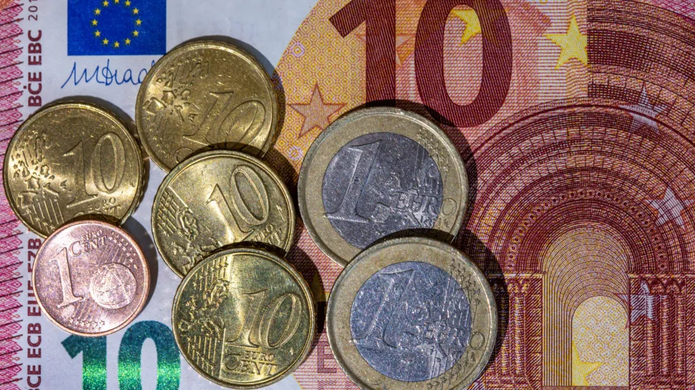 FILED - 26 June 2023, Berlin: Euro banknote and coins with a value of 12.41 euros lie on a table. Photo: Jan Woitas/dpa