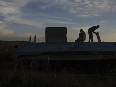 Workers of repair center are seen on the top of repaired MT-LB armored personnel carrier while testing it, in the Kyiv region, Ukraine, Tuesday, Oct. 24, 2023. (AP Photo/Alex Babenko)