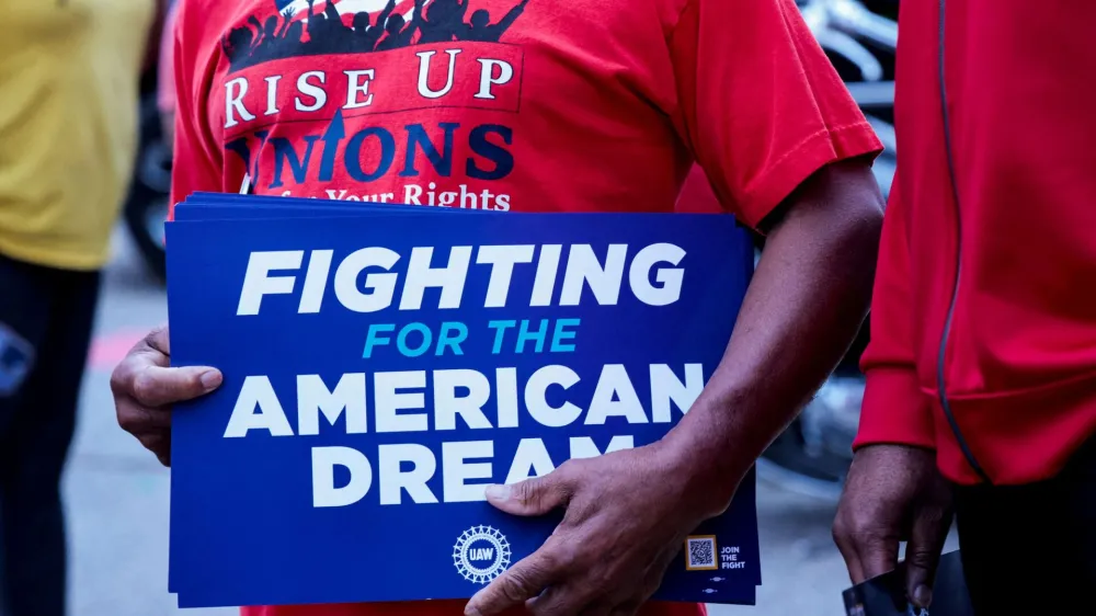 FILE PHOTO: A United Auto Workers union member holds a sign outside Stellantis Sterling Heights Assembly Plant, to mark the beginning of contract negotiations in Sterling Heights, Michigan, U.S. July 12, 2023. REUTERS/Rebecca Cook/File Photo