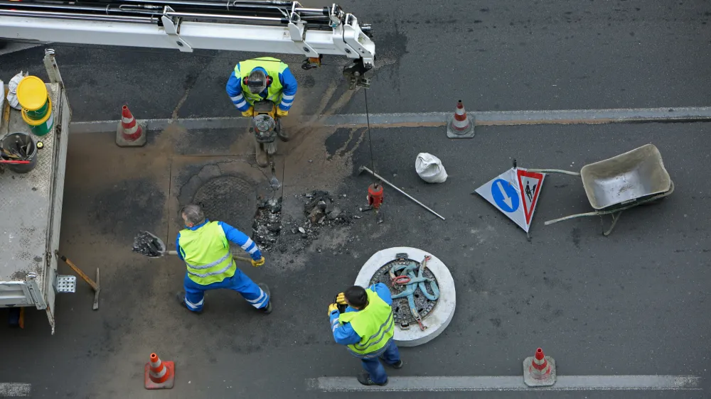 ﻿- simbolična fotografija - Kopitarjeva ulica v LJubljani - delo na cesti - cestni delavci - kanalizacijski jašek - //FOTO: Tomaž Skale