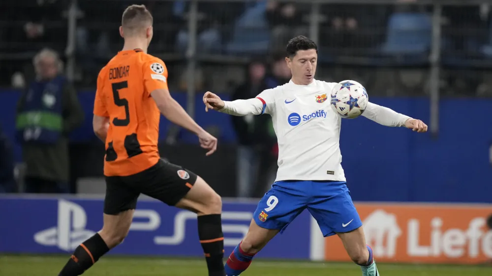 Barcelona's Robert Lewandowski, right, controls the ball as Shakhtar's Valeriy Bondar defends during the Champions League Group H soccer match between Shakhtar Donetsk and Barcelona, at the Volksparkstadion in Hamburg, Germany, Tuesday, Nov. 7, 2023. (AP Photo/Matthias Schrader)