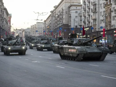 New Russian T-14 Armata tanks, foreground, make their way to Red Square during a rehearsal for the Victory Day military parade which will take place at Moscow's Red Square on May 9 to celebrate 70 years after the victory in WWII, in Moscow, Russia, Monday, May 4, 2015. Russia's new Armata tank has appeared in public for the first time, rumbling down a broad Moscow avenue on its way to Red Square for the Victory Day parade's final rehearsal. (AP Photo/Alexander Zemlianichenko)