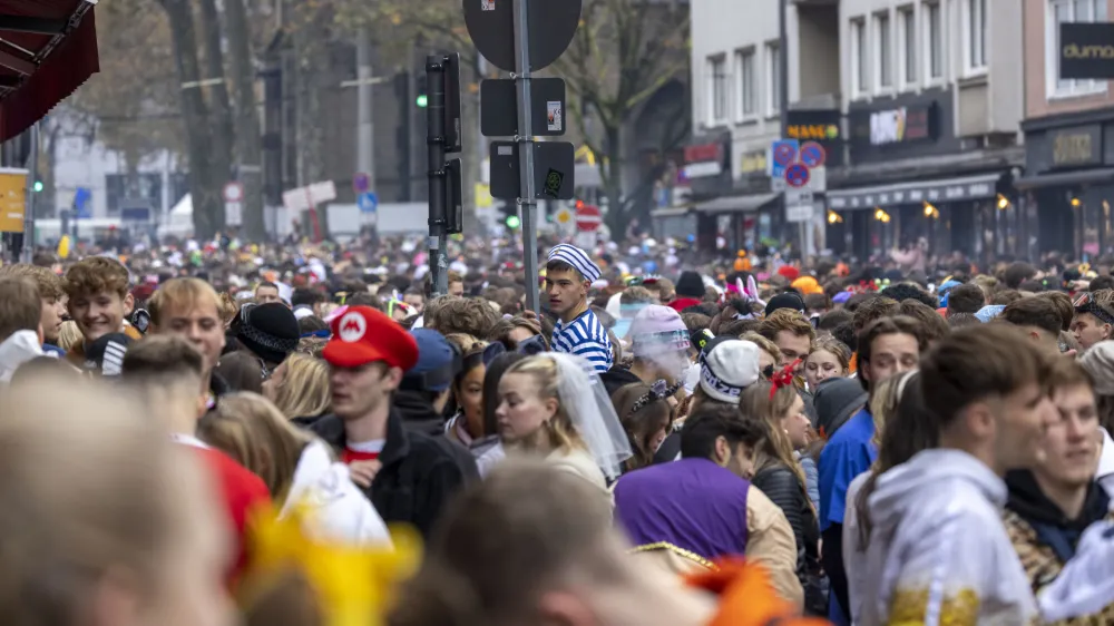 11 November 2023, North Rhine-Westphalia, Cologne: People gather at Zulpicher Strasse as they celebrate the 2023 Cologne Carnival. Photo: Thomas Banneyer/dpa
