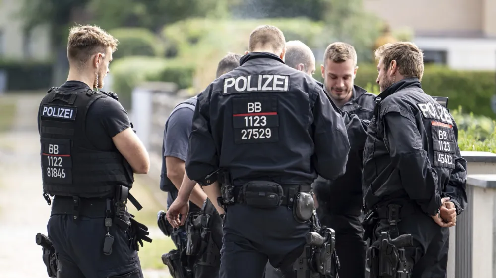 Police officers coordinate the search for a wild animal in a residential area in Teltow, Germany, Thursday July 20, 2023. German authorities warned people in Berlin's southern suburbs on Thursday to watch out for a potentially dangerous animal, suspected to be a lioness, that was on the loose. (Fabian Sommer/dpa via AP)