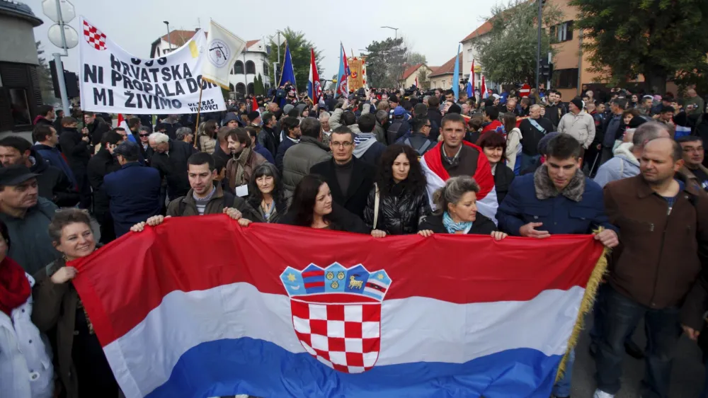 ﻿People carry a Croatian national flag during a ceremony to mark the 22th anniversary of Vukovar's fall, in downtown Vukovar November 18, 2013. The Danube town of Vukovar was entirely destroyed 22 years ago by Serb paramilitary forces backed by units of the former Yugoslav army at the beginning of Croatia's 1991-95 independence war. REUTERS/Antonio Bronic (CROATIA - Tags: CONFLICT ANNIVERSARY SOCIETY)