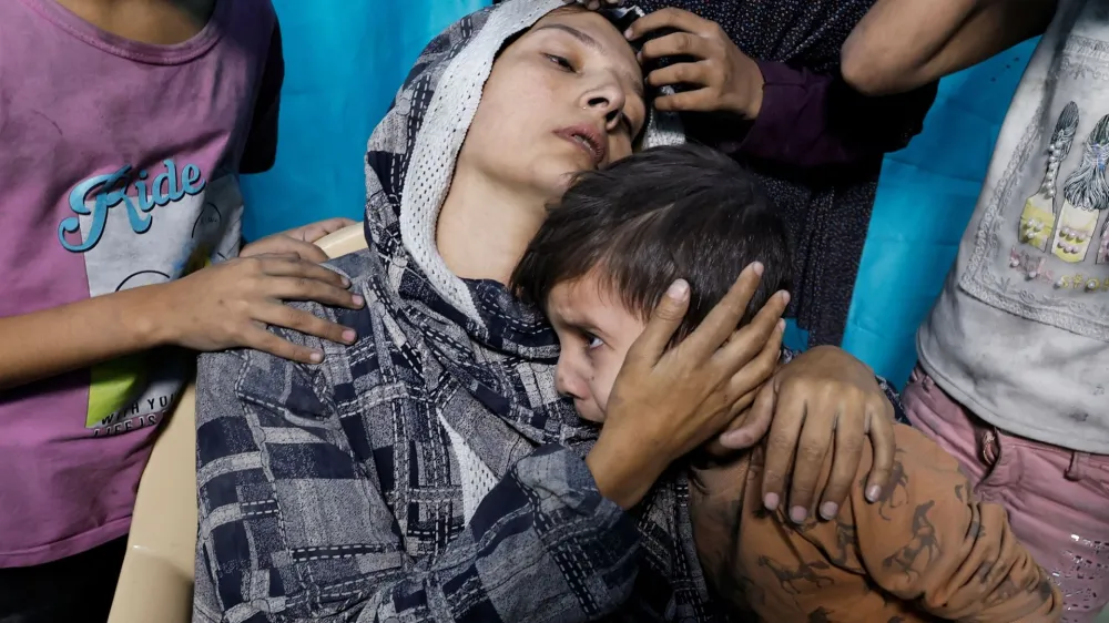 A Palestinian woman and children react after Israeli strikes, at a hospital in Khan Younis in the southern Gaza Strip November 13, 2023. REUTERS/Mohammed Salem