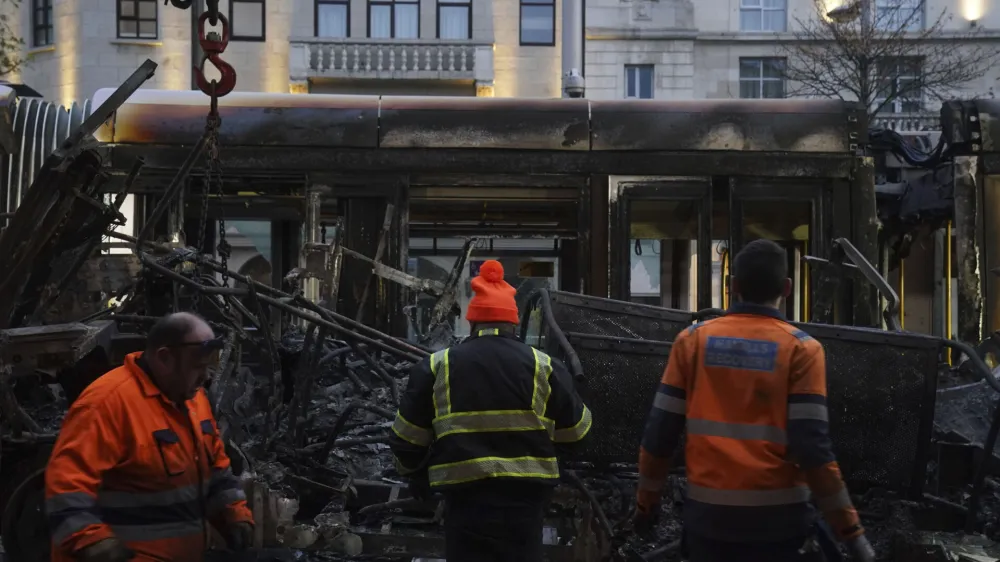 A burned out Luas is removed from O'Connell Street in the aftermath of violent scenes in the city centre on Thursday evening, in Dublin, early Friday, Nov. 24, 2023. The unrest came after an attack on Parnell Square East where five people were injured, including three young children. (Brian Lawless/PA via AP)