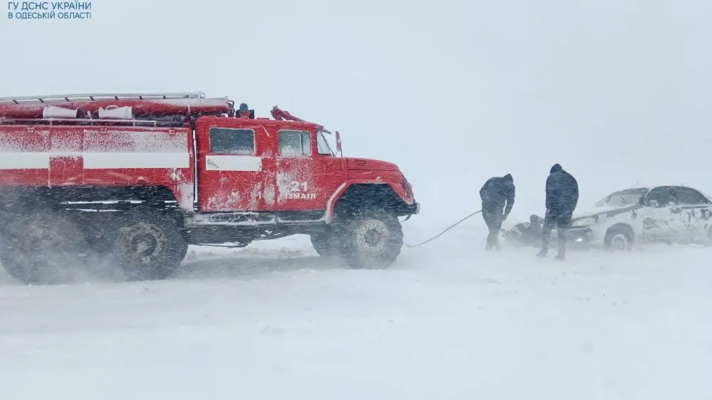 Emergency workers release a car which is stuck in snow during a heavy snow storm in Odesa region, Ukraine November in this handout picture released November 27, 2023. Press service of the State Emergency Service of Ukraine in Odesa region/Handout via REUTERS ATTENTION EDITORS - THIS IMAGE HAS BEEN SUPPLIED BY A THIRD PARTY.