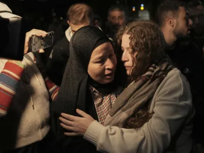 Palestinian activist Ahed Tamimi, right, is greeted by her mother after she was released from prison by Israel, in the West Bank town of Ramallah, early Thursday, Nov. 30, 2023. International mediators on Wednesday worked to extend the truce in Gaza, encouraging Hamas militants to keep freeing hostages in exchange for the release of Palestinian prisoners and further relief from Israel's air and ground offensive. (AP Photo/Nasser Nasser)