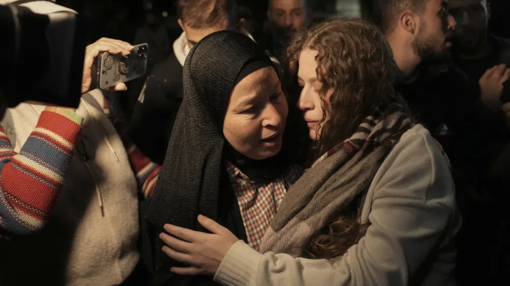 Palestinian activist Ahed Tamimi, right, is greeted by her mother after she was released from prison by Israel, in the West Bank town of Ramallah, early Thursday, Nov. 30, 2023. International mediators on Wednesday worked to extend the truce in Gaza, encouraging Hamas militants to keep freeing hostages in exchange for the release of Palestinian prisoners and further relief from Israel's air and ground offensive. (AP Photo/Nasser Nasser)