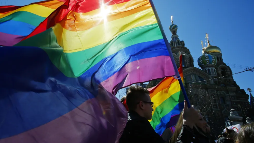 FILE - Gay rights activists carry rainbow flags as they march during a May Day rally in St. Petersburg, Russia, Wednesday, May 1, 2013. Russia's Supreme Court on Thursday, Nov. 30, 2023, effectively outlawed LGBTQ+ activism, in the most drastic step against advocates of gay, lesbian and transgender rights in the increasingly conservative country. (AP Photo, File)