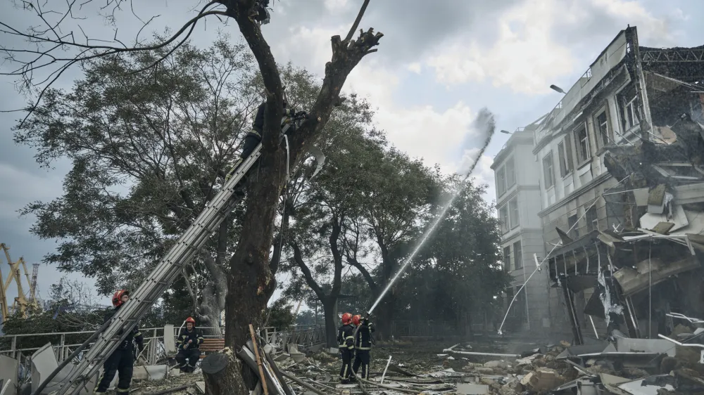 Emergency service personnel work at the site of a destroyed building after a Russian attack in Odesa, Ukraine, Thursday, July 20, 2023. Russia pounded Ukraine's southern cities, including the port city of Odesa, with drones and missiles for a third consecutive night in a wave of strikes that has destroyed some of the country's critical grain export infrastructure. (AP Photo/Libkos)